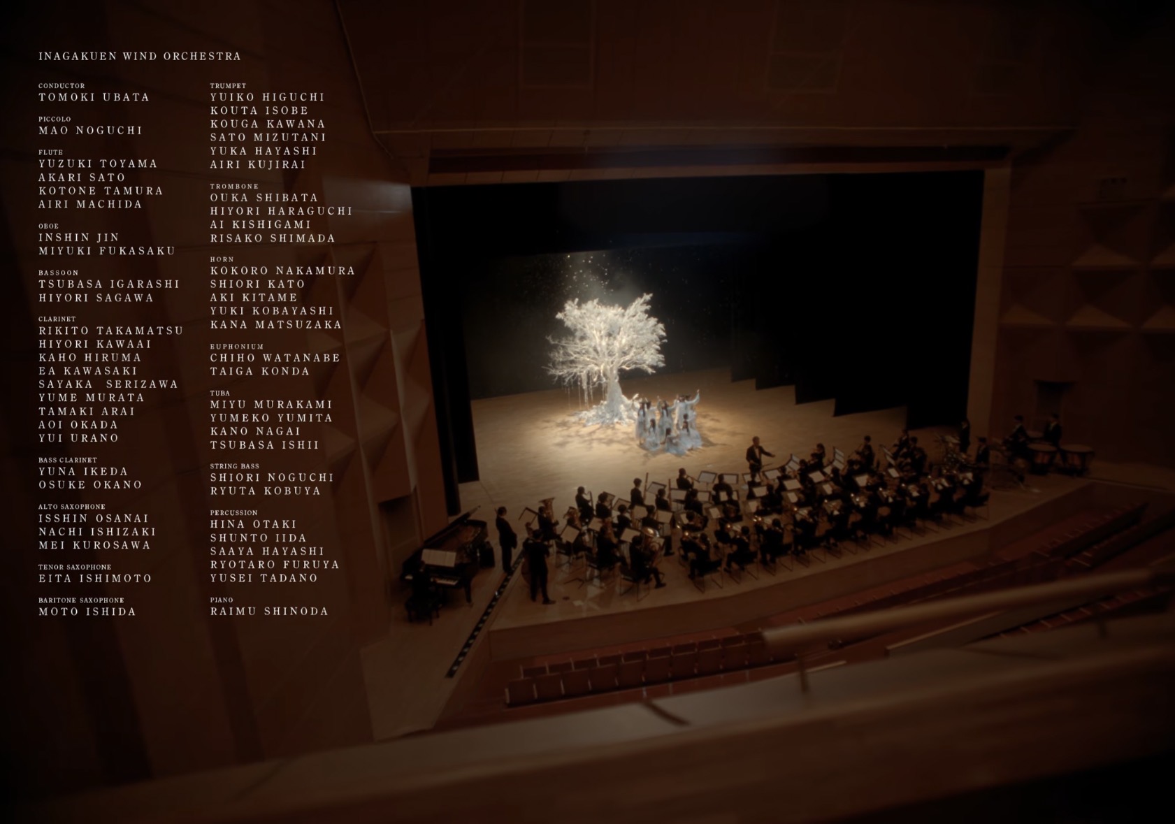 白い木と五期生のいる舞台、手前に並ぶ吹奏楽の演奏者、画面左のクレジットを収めたラストカット